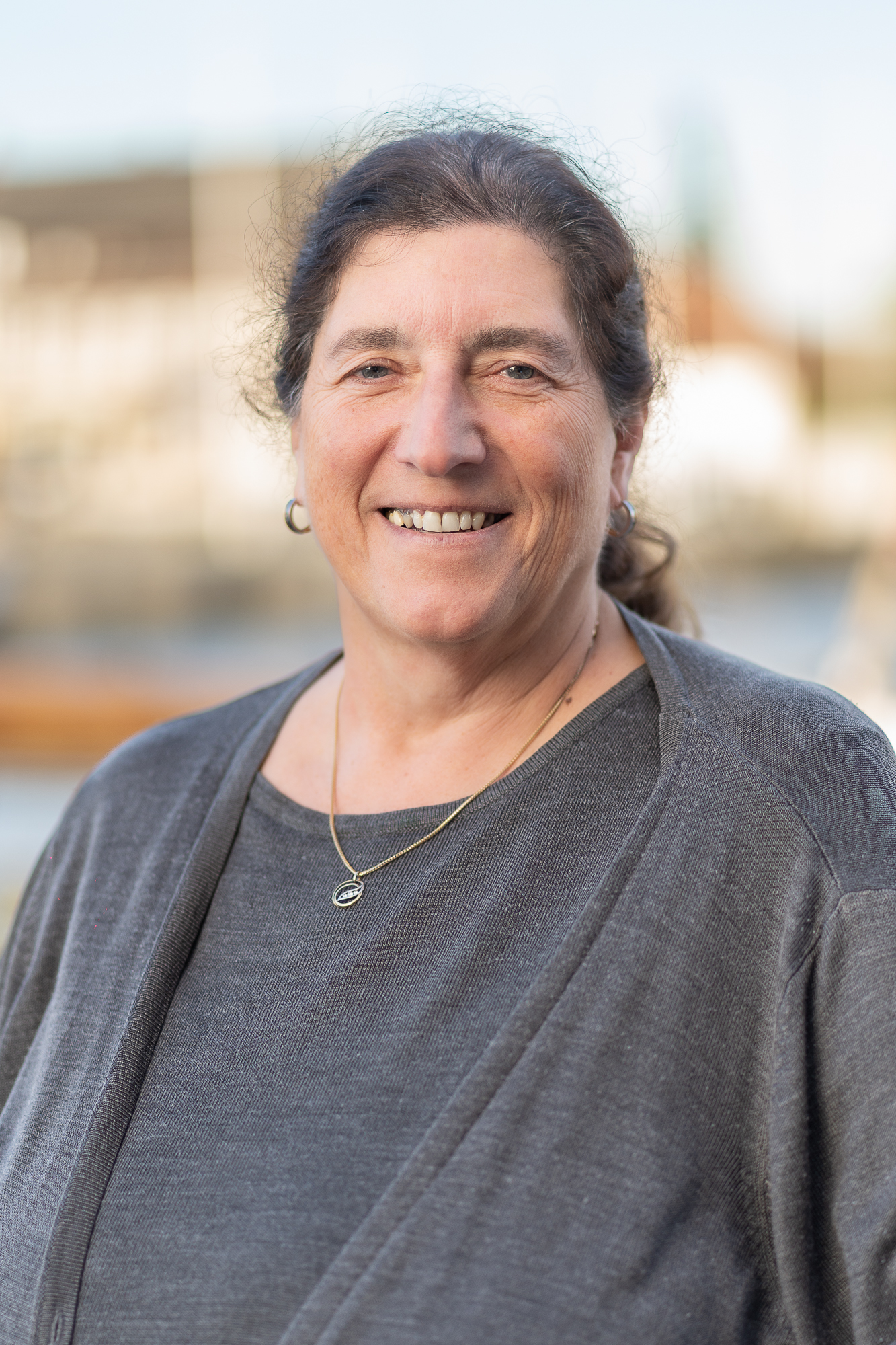 Mitarbeiterin der Steuerkanzlei vor maritimem Hintergrund.