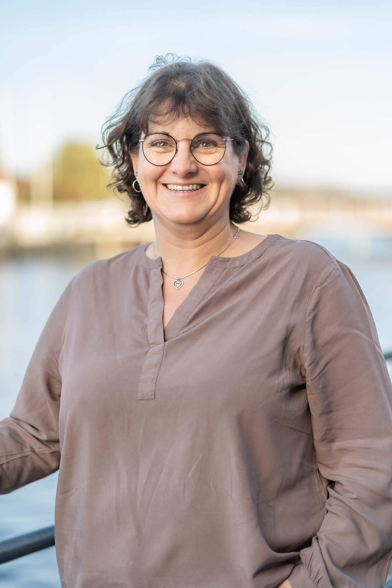 Mitarbeiterin der Steuerkanzlei vor unscharfem Hafenumfeld.